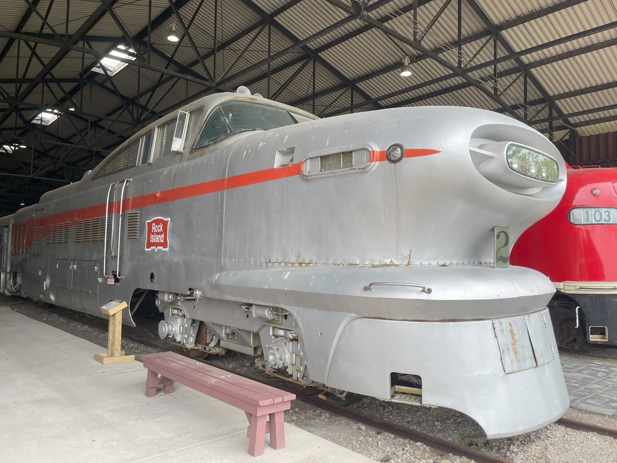 A silver locomotive that looks like it came out of the Jetsons. It has a red streak down the side and a badge that says "Rock Island". The cab sits on top almost like a car with a long hood