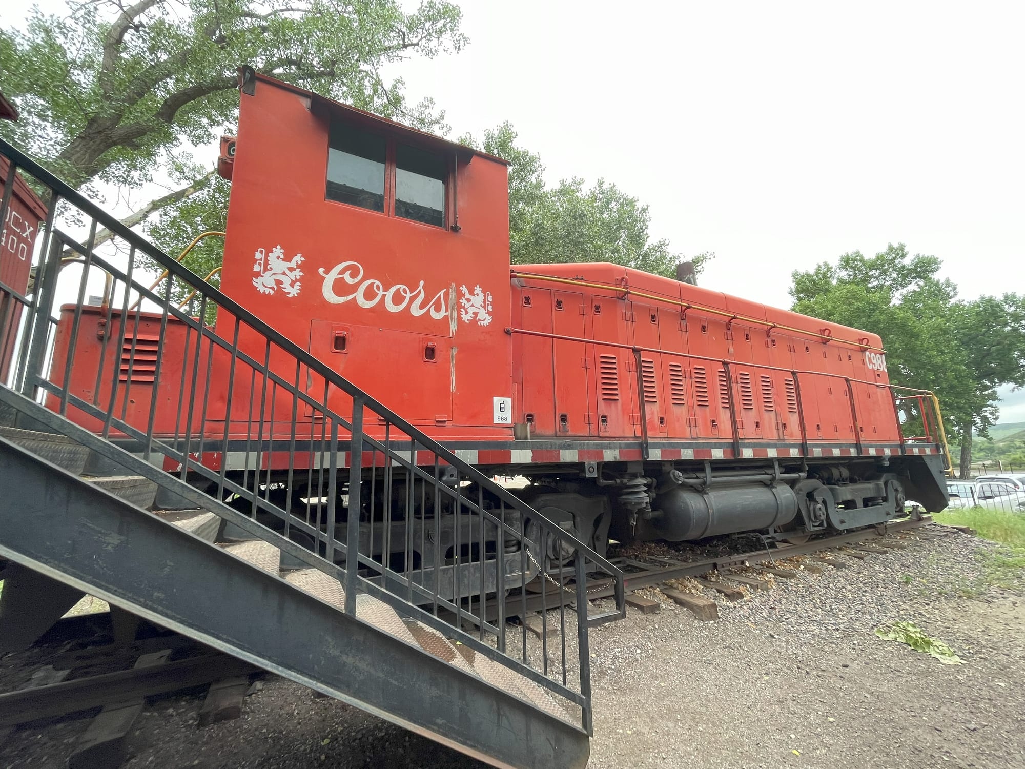 A red diesel electric switching locomotive with the Coors beer logo on the cab
