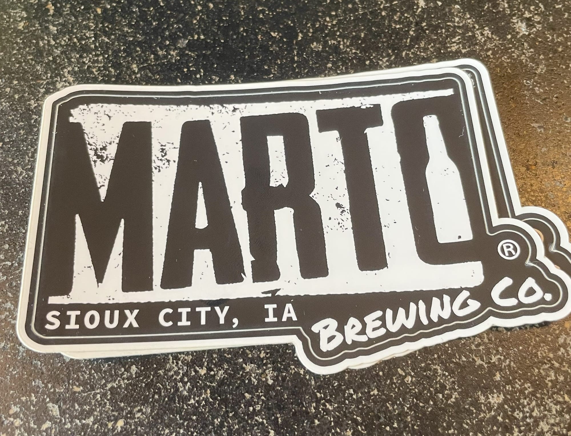 Black and white sticker on a granite countertop that says "Marto Brewing Co. Sioux City, IA"