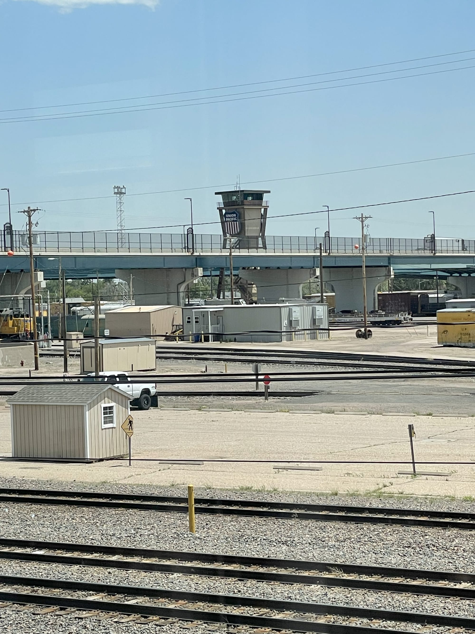 A bridge over railroad tracks. In the center a giant control tower rises above the bridge with a red, white, and blue shield that says "Union Pacific"